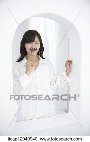 woman wearing white shirt and holding a mustache figure View Large Photo Image Stock Image - woman wearing white shirt and holding a mustache figure. Fotosearch