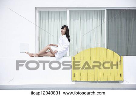 woman wearing white shirt and sitting on the wall View Large Photo Image Stock Image - woman wearing white shirt and sitting on the wall. Fotosearch