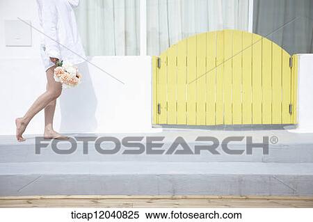 woman wearing white shirt and walking next to the house with a bouquet View Large Photo Image Stock Photography - woman wearing white shirt and walking next to the house with a bouquet. Fotosearch