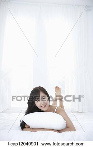 woman wearing white sleepwear and lying on the pillow View Large Photo Image Stock Image - woman wearing white sleepwear and lying on the pillow. Fotosearch