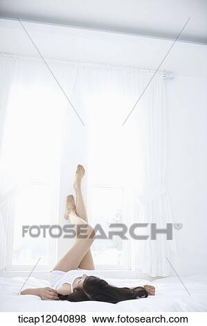 woman wearing white sleepwear and lying on the bed View Large Photo Image Stock Photo - woman wearing white sleepwear and lying on the bed . Fotosearch