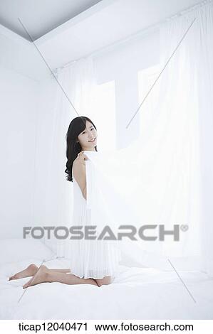 woman wearing white sleepwear and holding white curtain on the bed View Large Photo Image Stock Image - woman wearing white sleepwear and holding white curtain on the bed. Fotosearch