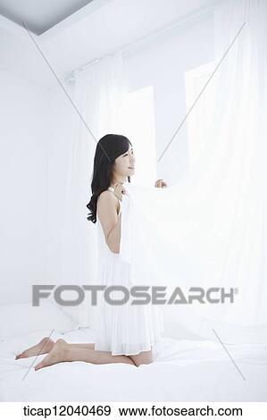 woman wearing white sleepwear and holding white curtain on the bed View Large Photo Image Stock Photo - woman wearing white sleepwear and holding white curtain on the bed. Fotosearch