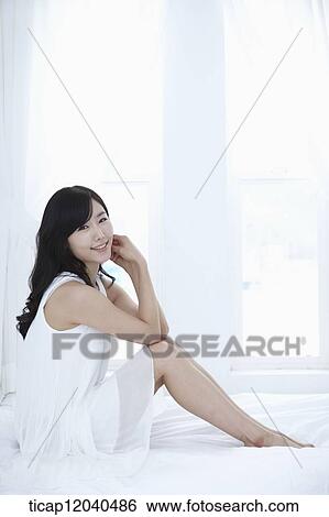 woman wearing white sleepwear and sitting on the bed View Large Photo Image Stock Photograph - woman wearing white sleepwear and sitting on the bed . Fotosearch