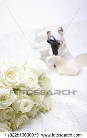 Stock Illustration - a bucket of white roses and tiny wedding figures. Fotosearch
