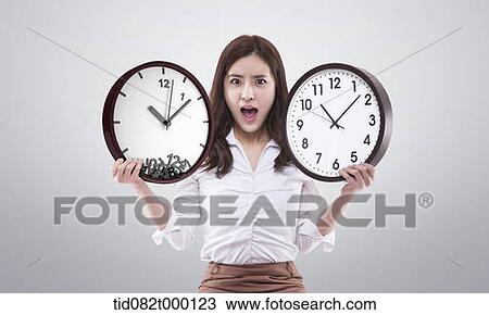 Drawing - a business woman holding two clocks. Fotosearch