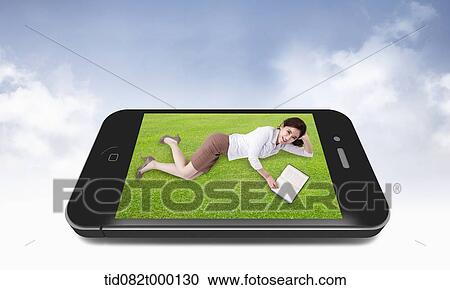 Clipart - a business woman lying on grass in a mobile phone. Fotosearch