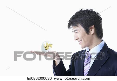 Clipart - a businessman holding dollar sign. Fotosearch
