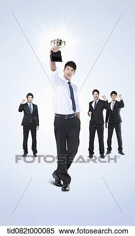 Stock Illustration - a businessman with a trophy. Fotosearch