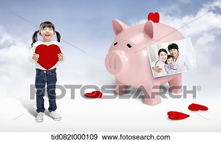 Stock Illustration - a kid holding a heart next to piggy bank. Fotosearch