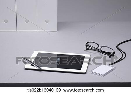 Stock Illustration - a tablet next to glasses. Fotosearch