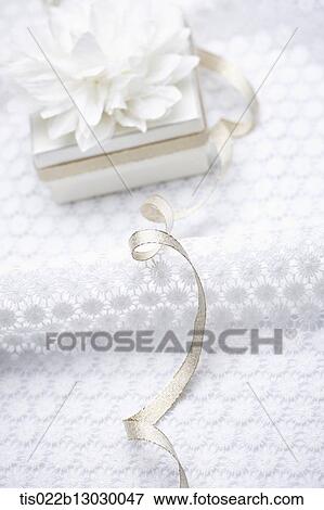 a white present with a flower View Large Illustration Stock Illustration - a white present with a flower. Fotosearch