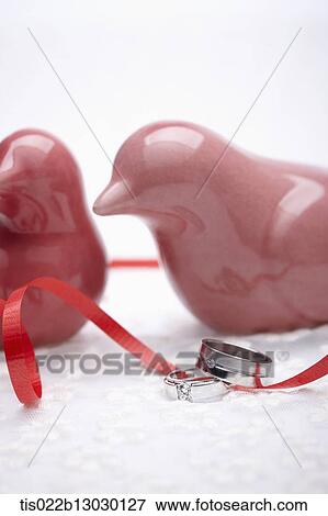 red porcelain birds, red ribbon and wedding rings View Large Illustration Stock Illustration - red porcelain birds, red ribbon and wedding rings. Fotosearch