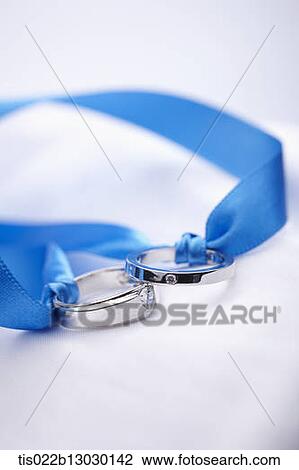 Drawing - wedding rings in a blue ribbon. Fotosearch