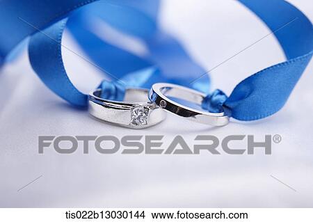 Stock Illustration - wedding rings in a blue ribbon. Fotosearch