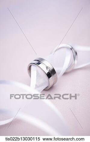 Stock Illustration - wedding rings in a white ribbon. Fotosearch