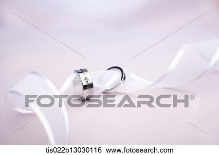 Stock Illustration - wedding rings in a white ribbon. Fotosearch