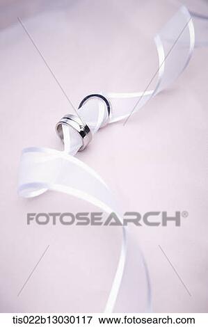 Stock Illustration - wedding rings in a white ribbon. Fotosearch