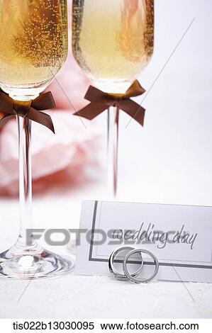 Stock Illustration - wedding rings with champagne and flowers. Fotosearch