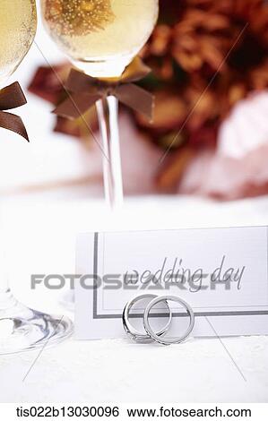 Stock Illustration - wedding rings with champagne and flowers. Fotosearch