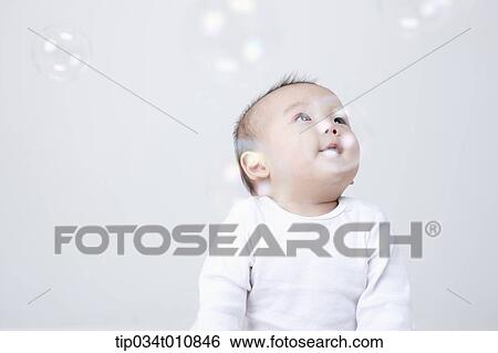 a baby and bubbles in the air View Large Photo Image Stock Photograph - a baby and bubbles in the air . Fotosearch