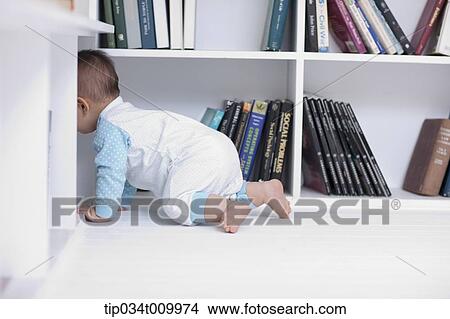 Picture - a baby crawling under a desk . Fotosearch
