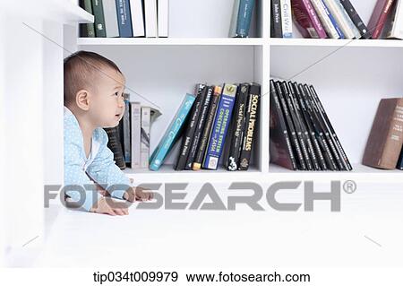 Stock Photo - a baby crawling under a desk . Fotosearch
