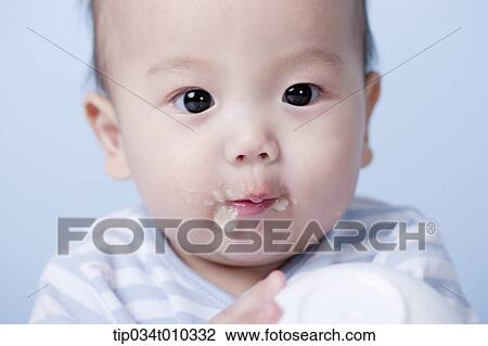 Stock Image - a baby having food . Fotosearch