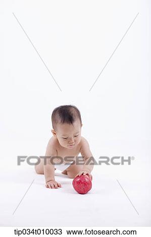 a baby in diaper crawling to an apple View Large Photo Image Stock Image - a baby in diaper crawling to an apple. Fotosearch
