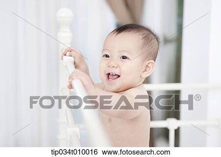 a baby in diaper playing in the crib View Large Photo Image Stock Photograph - a baby in diaper playing in the crib. Fotosearch