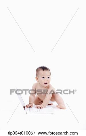 Stock Photo - a baby in diaper playing with a laptop. Fotosearch