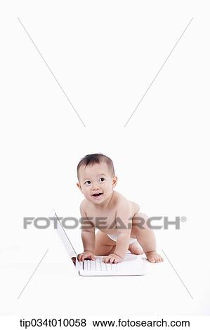 Stock Photo - a baby in diaper playing with a laptop. Fotosearch