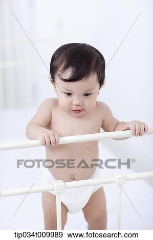 a baby in diaper standing in the crib View Large Photo Image Stock Photo - a baby in diaper standing in the crib. Fotosearch