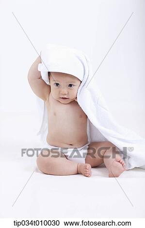 Stock Image - a baby in diaper under white blanket on white background. Fotosearch