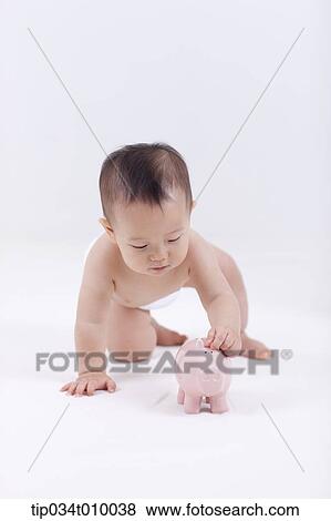Stock Photo - a baby in diaper with a piggy bank. Fotosearch