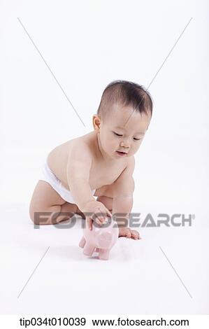 Stock Photo - a baby in diaper with a piggy bank. Fotosearch
