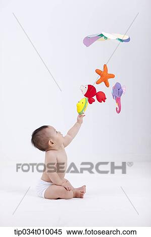 A Baby In Diaper With Mobiles Hanging In The Ceiling Stock Photography