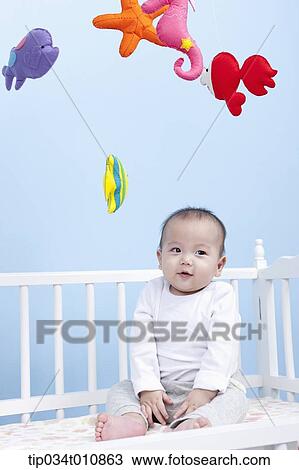 a baby inside a crib playing with mobile View Large Photo Image Stock Image - a baby inside a crib playing with mobile. Fotosearch