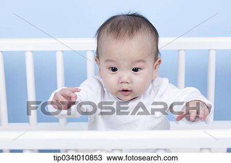 Stock Image - a baby inside a crib. Fotosearch