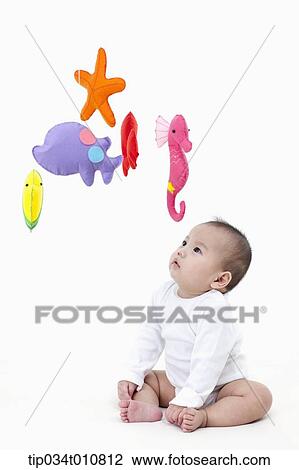 Stock Image - a baby looking at mobile in the ceiling. Fotosearch