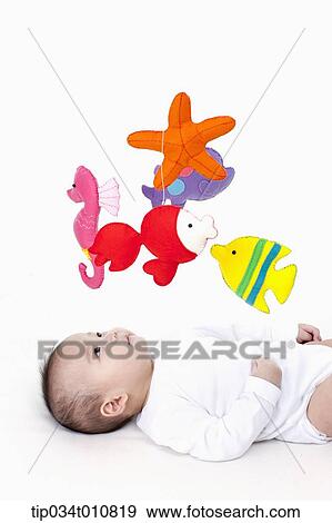 Stock Photo - a baby looking at mobile in the ceiling. Fotosearch