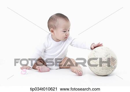 Stock Image - a baby playing with a globe. Fotosearch