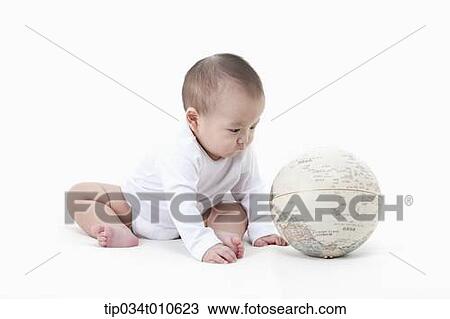 Stock Image - a baby playing with a globe. Fotosearch