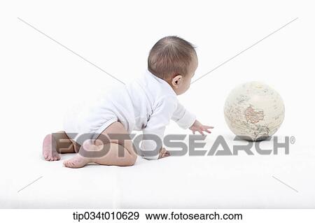 Stock Photo - a baby playing with a globe. Fotosearch