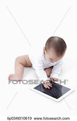 a baby playing with a tablet PC View Large Photo Image Stock Photo - a baby playing with a tablet PC. Fotosearch