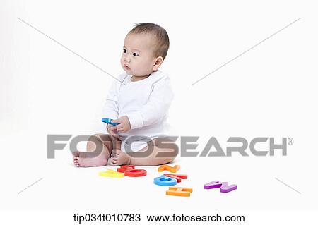 Stock Image - a baby playing with alphabet blocks. Fotosearch