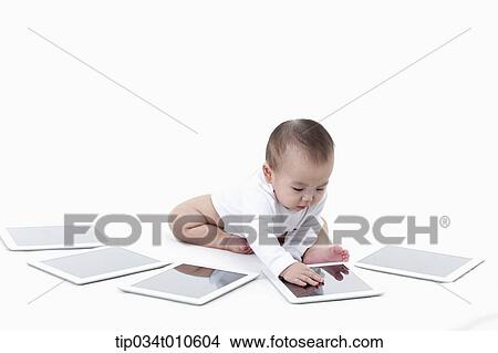 a baby playing with several tablet PCs View Large Photo Image Picture - a baby playing with several tablet PCs. Fotosearch