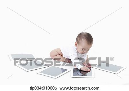 a baby playing with several tablet PCs View Large Photo Image Stock Photography - a baby playing with several tablet PCs. Fotosearch