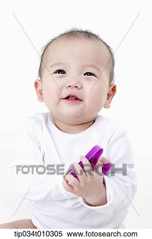 Stock Photography - a baby smiling while playing with alphabet block. Fotosearch