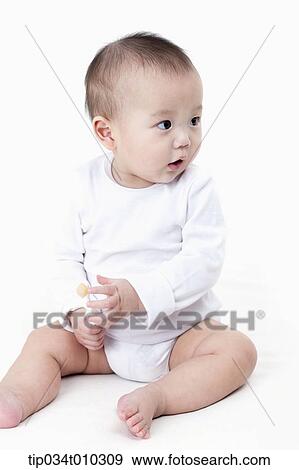 Stock Photo - a baby with a baby toothbrush. Fotosearch